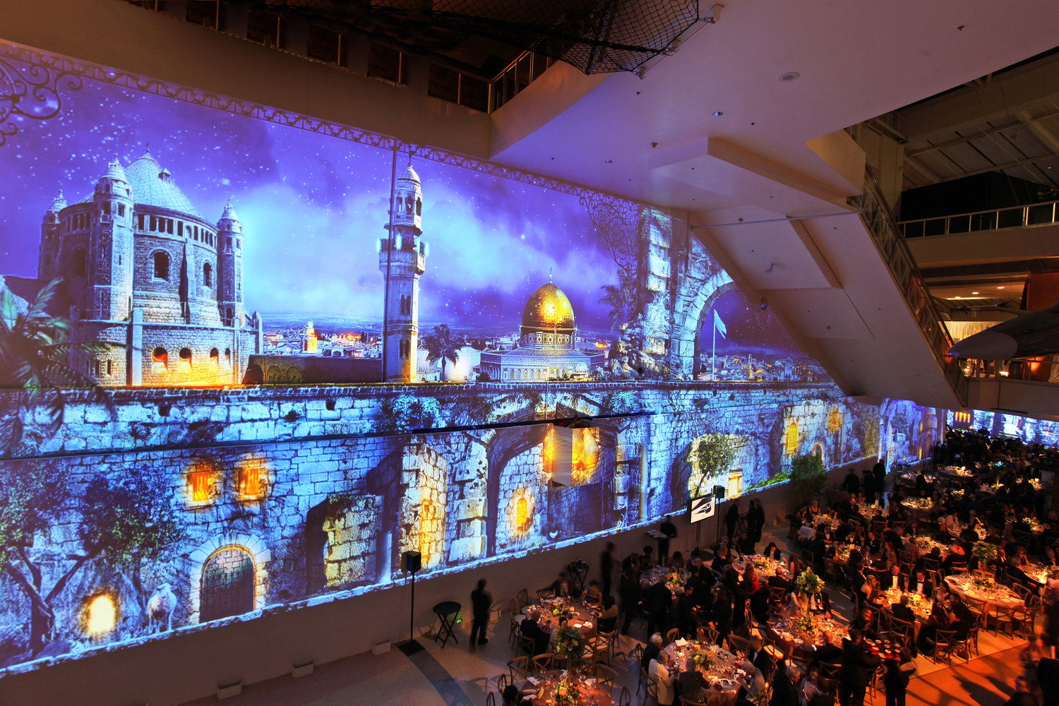Edgerton Court seated dinner with blue hued night projection mapping of Jerusalem