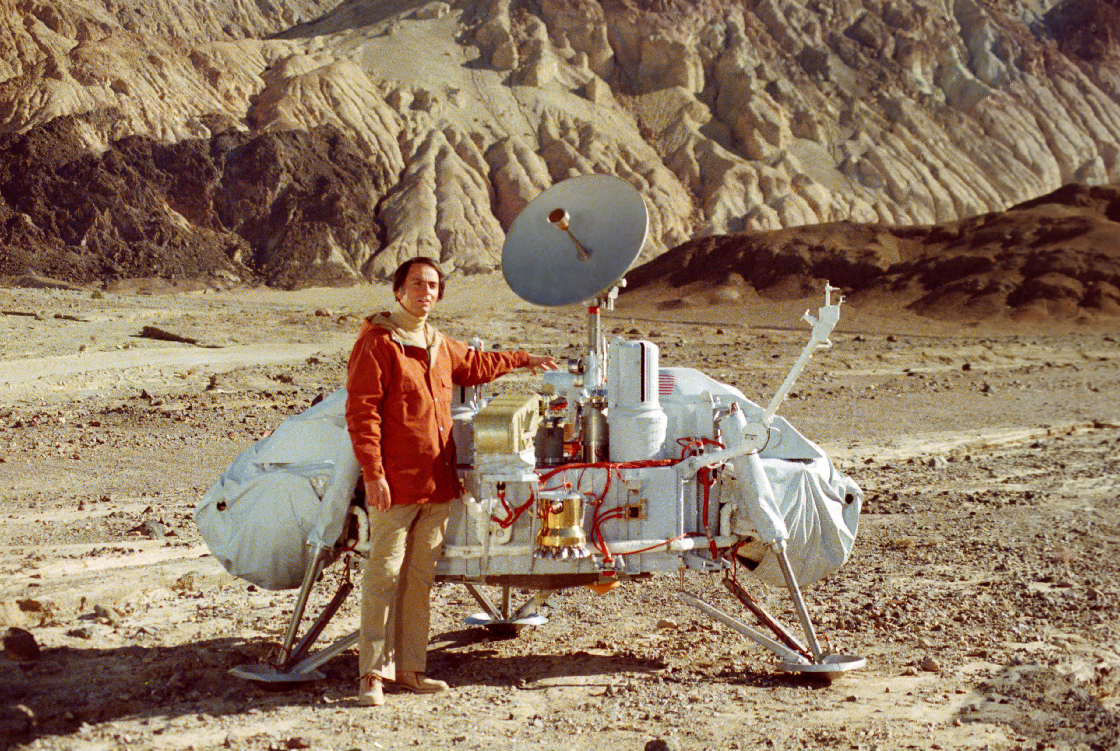 Carl Sagan poses with a model of the Viking lander in Death Valley, California