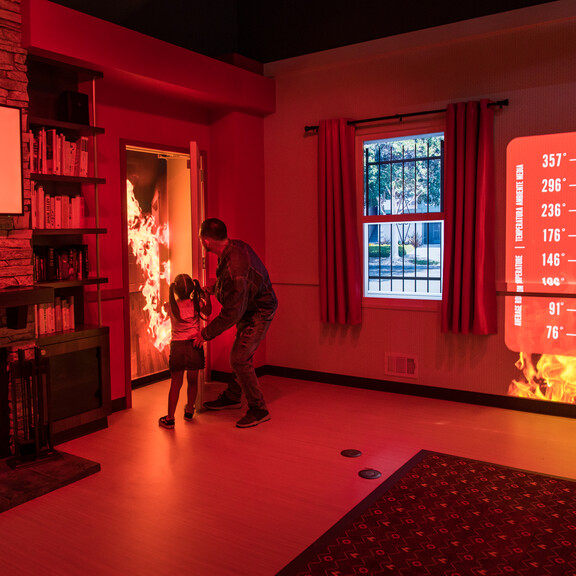 Realistic-looking fires appear to burn on the wall and inside a door of the Fire! Science & Safety exhibition.