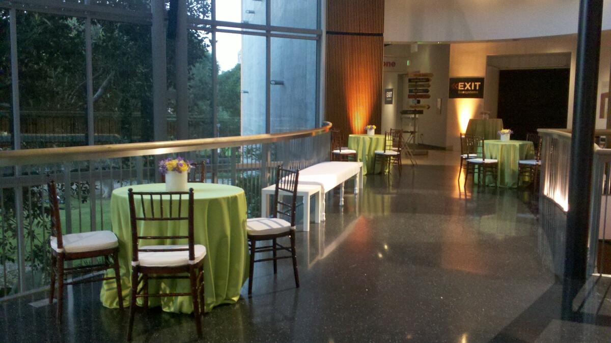Light green cocktail tables with wooden chairs on Ecosystems second floor corridor