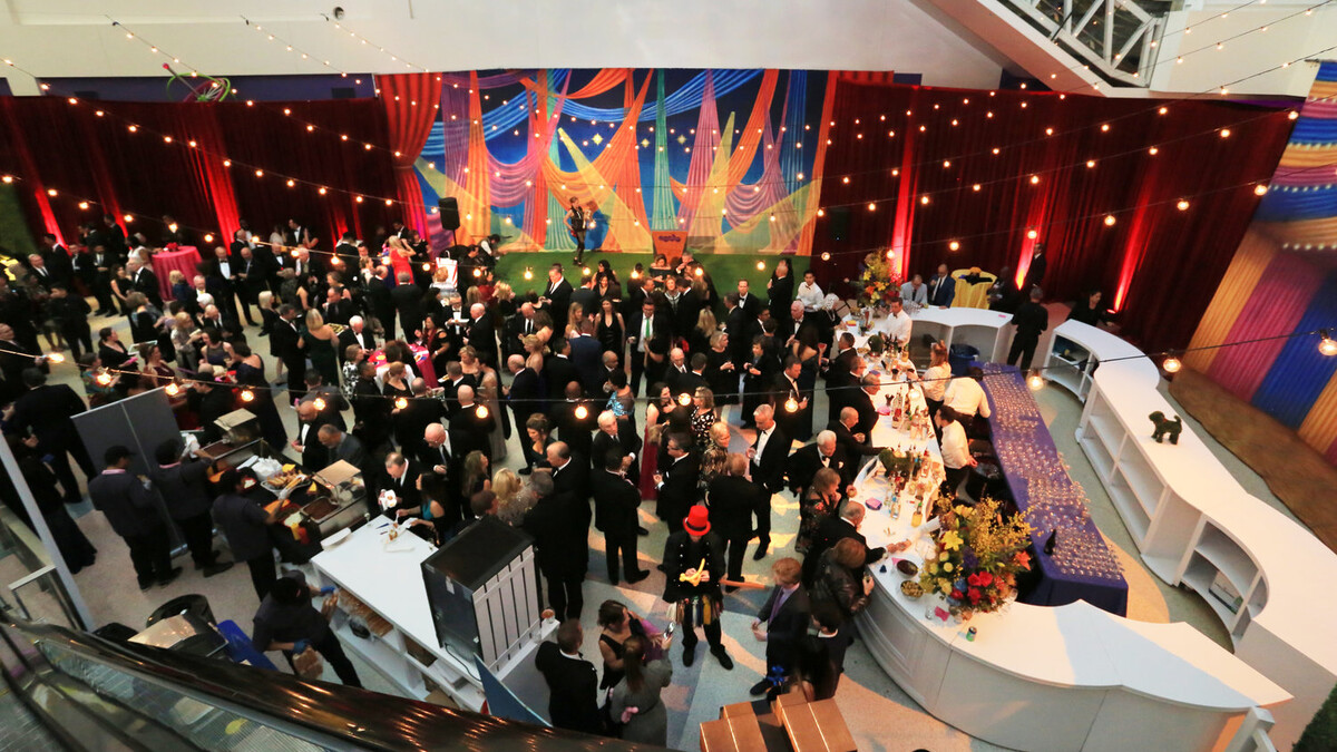 Side view of event guest mingling in Edgerton Court decorated with dog bone shaped bar and stringer lights