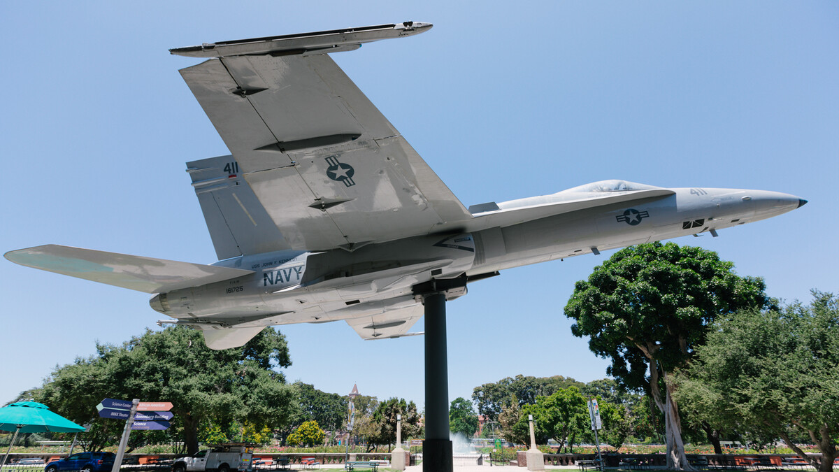The Science Center's F/A-18A Hornet sits perched outside the north entrance with the Rose Garden behind it.