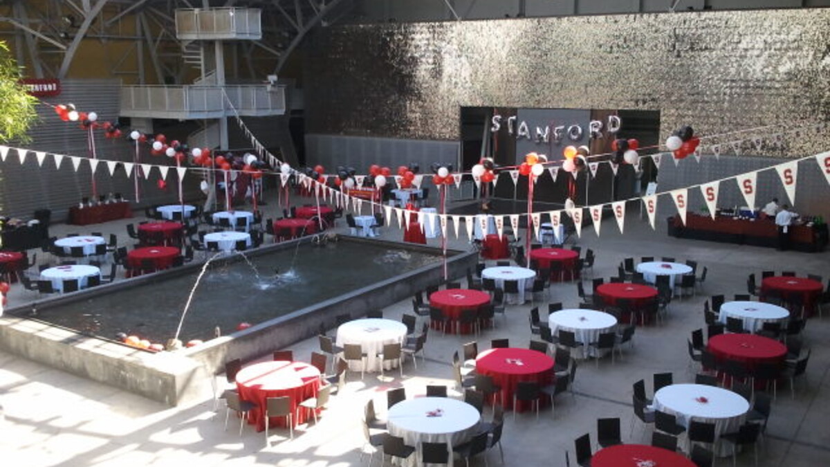 Tailgate in the Wallis Annenberg Building with Red and White banquet tables and overhead pennants and balloons