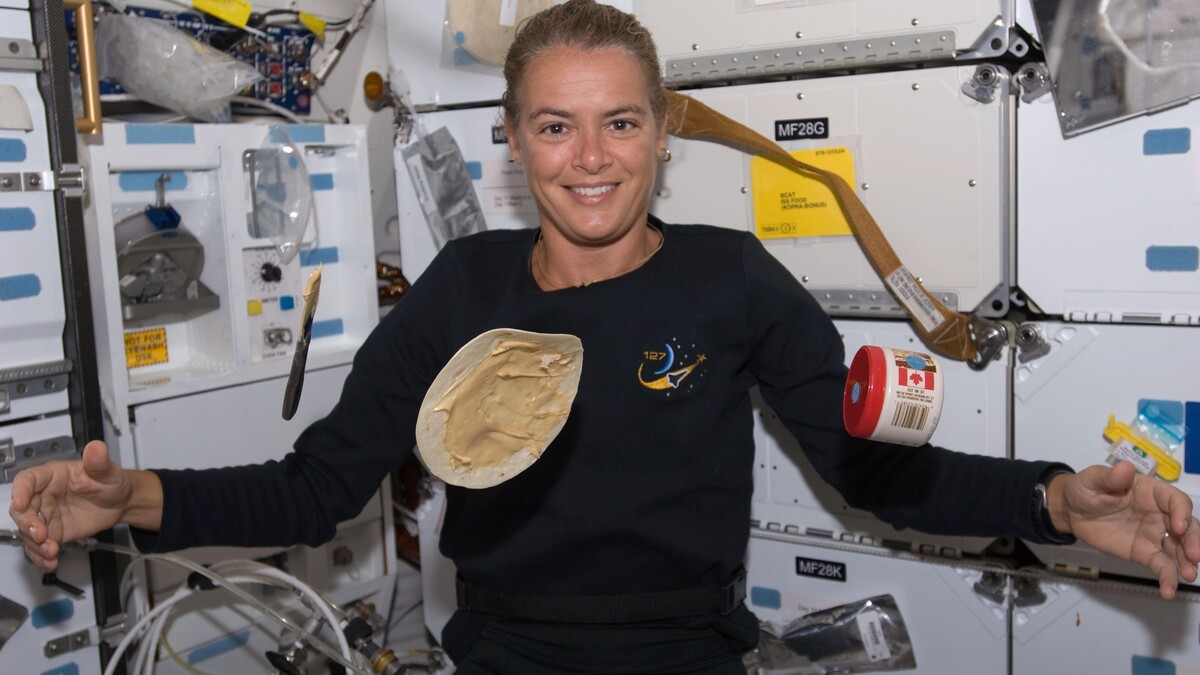 Astronaut Julie Payette floats a tortilla inside space shuttle Endeavour.