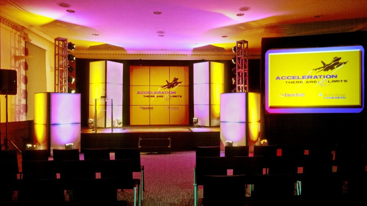 MUSES Room set theater style facing dramatic pink and yellow illuminated custom stage