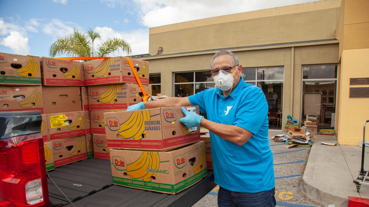 Ruben Corona, executive director of Weingart East Los Angeles YMCA, distributes boxes of food from the back of a pickup truck